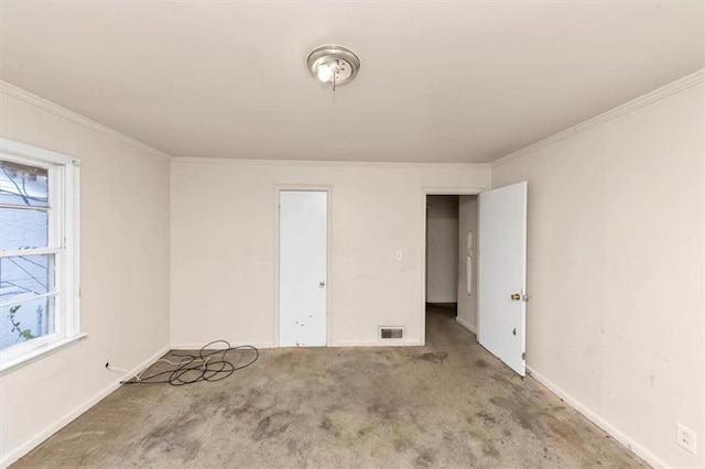 unfurnished bedroom with baseboards, carpet, visible vents, and crown molding