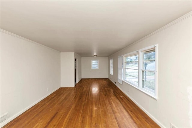 unfurnished room featuring baseboards, wood finished floors, and ornamental molding