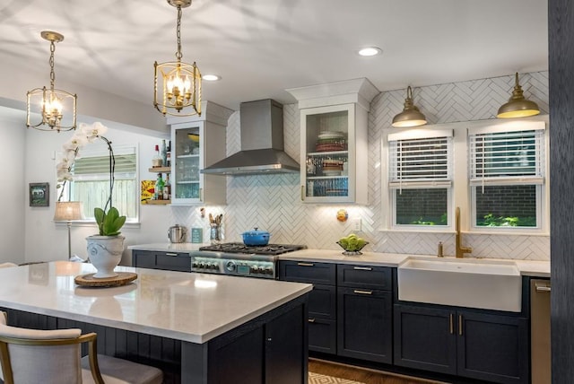 522 Trabert Ave NW, Atlanta, GA 30309 - kitchen featuring wall chimney exhaust hood, a chandelier, tasteful backsplash, a kitchen island, and hanging light fixtures