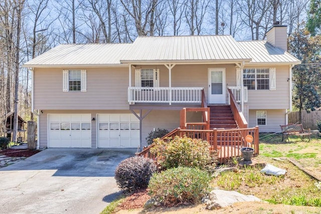 view of front of home with a chimney, covered porch, an attached garage, metal roof, and stairs