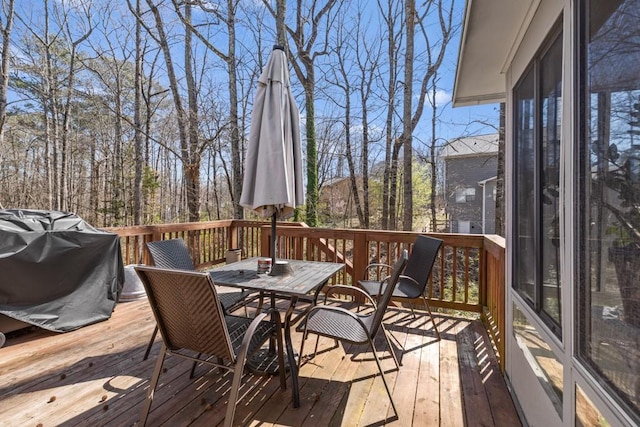 wooden terrace with grilling area and outdoor dining space