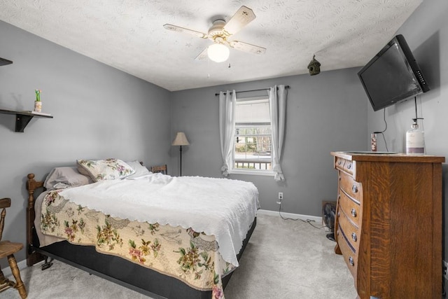 bedroom featuring ceiling fan, a textured ceiling, baseboards, and carpet floors