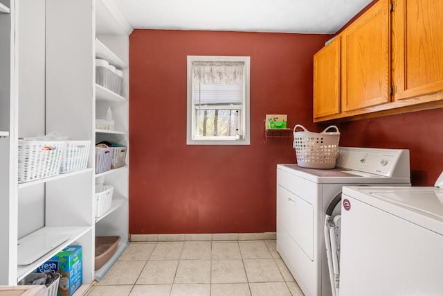 laundry room featuring light tile patterned floors, baseboards, cabinet space, and independent washer and dryer