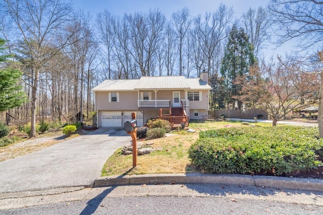 view of front of property with stairs, covered porch, concrete driveway, an attached garage, and a chimney