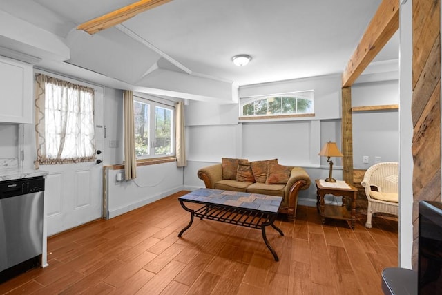 living room with lofted ceiling with beams, baseboards, and wood finished floors