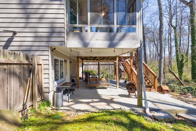 view of patio with stairs and fence