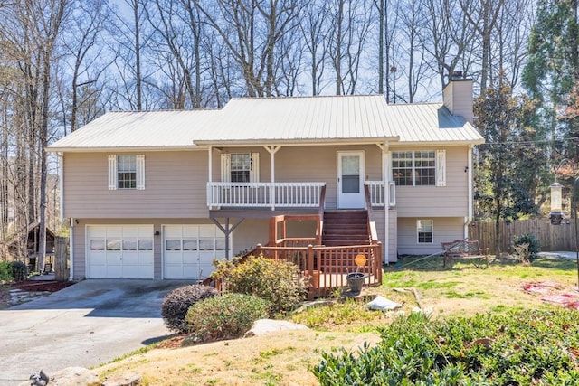 view of front of house featuring stairway, an attached garage, covered porch, a chimney, and metal roof