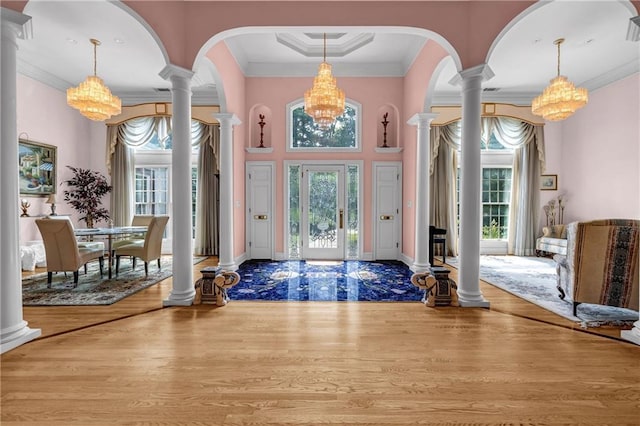 foyer with a chandelier, decorative columns, ornamental molding, and a towering ceiling