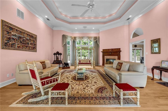 living room featuring plenty of natural light, ceiling fan, light wood-style floors, ornamental molding, and recessed lighting