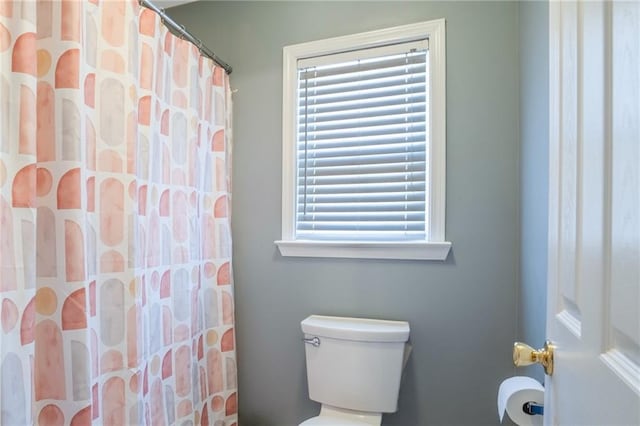 full bathroom featuring toilet and curtained shower