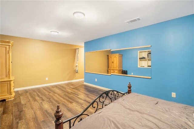 bedroom featuring dark wood-style floors, visible vents, and baseboards