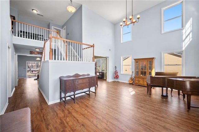 foyer entrance featuring baseboards, stairway, dark wood finished floors, and a chandelier