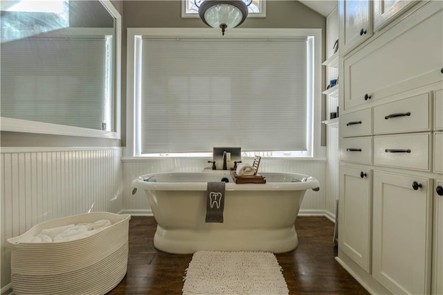 bathroom with a washtub and wood-type flooring