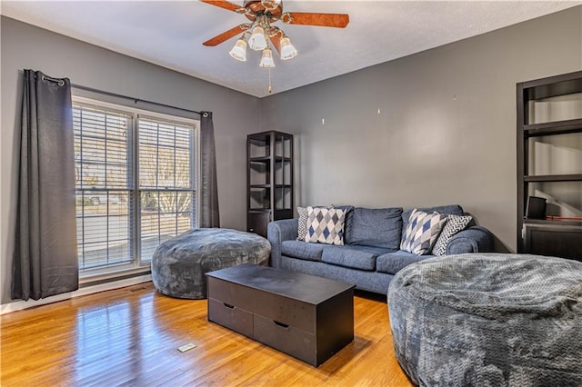 living room with wood-type flooring and ceiling fan