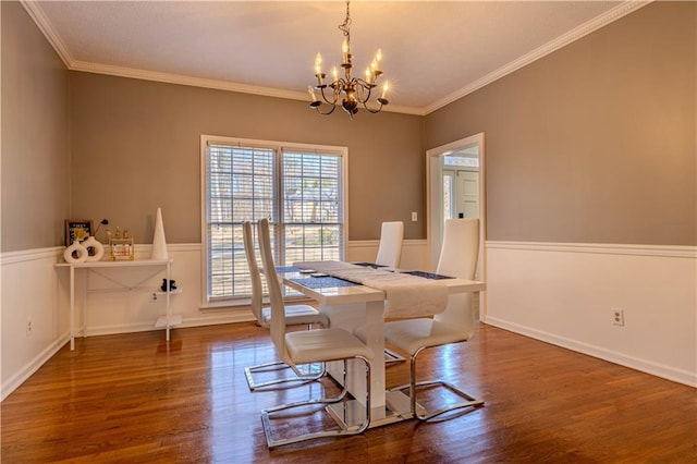 dining space with a notable chandelier, ornamental molding, and dark wood-type flooring