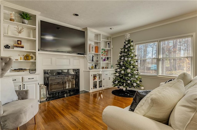 living room with hardwood / wood-style flooring, a premium fireplace, crown molding, and a textured ceiling