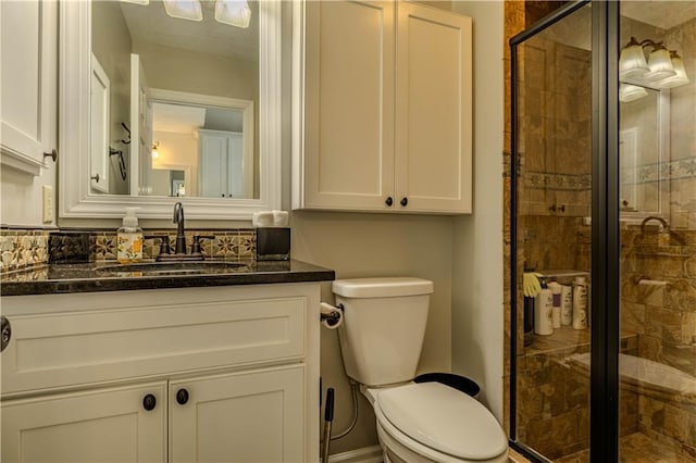 bathroom with vanity, toilet, and a shower with door