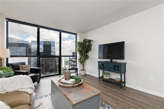 living area featuring floor to ceiling windows, wood finished floors, baseboards, and a textured ceiling