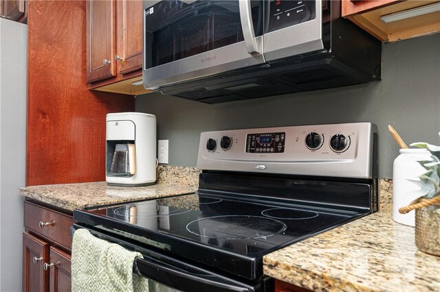 kitchen view of a sink, dishwashing machine, and light stone countertops