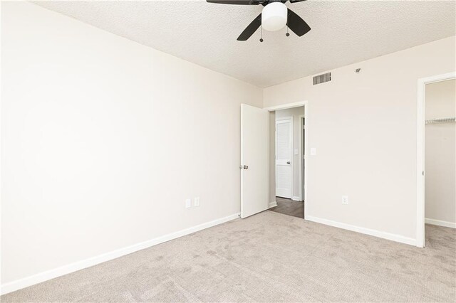 spare room with carpet floors, expansive windows, a ceiling fan, a textured ceiling, and baseboards