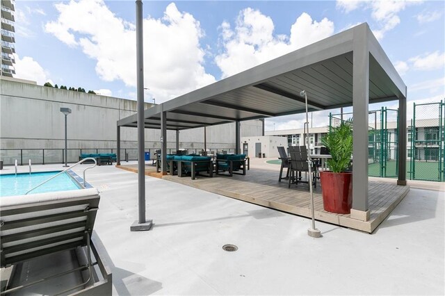 view of patio / terrace featuring fence and a community pool