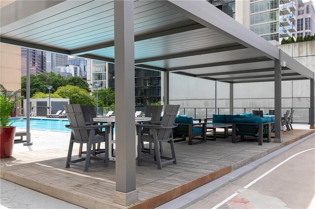 view of patio with an outdoor living space, a community pool, outdoor dining space, a view of city, and fence