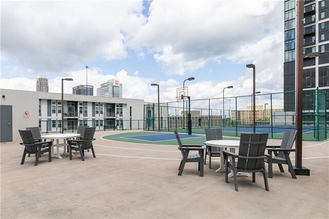 view of basketball court with a tennis court, community basketball court, and fence