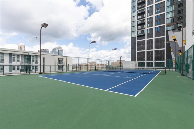 view of tennis court featuring fence