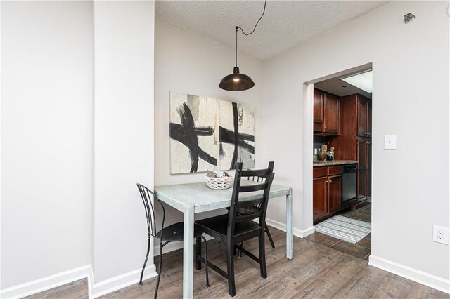 living area featuring wood finished floors, expansive windows, a textured ceiling, and baseboards