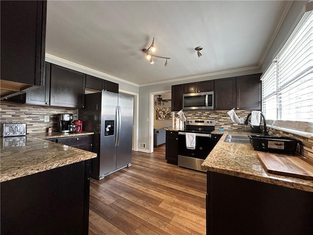 5862 Kitchens Rd SE, Mableton, GA 30126 - kitchen featuring sink, crown molding, appliances with stainless steel finishes, hardwood / wood-style floors, and backsplash