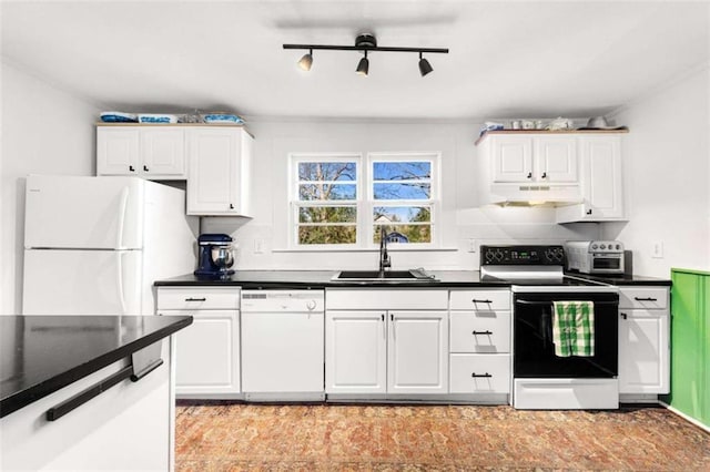 kitchen with white appliances, dark countertops, under cabinet range hood, and a sink