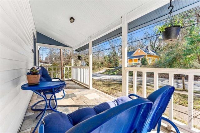 sunroom / solarium featuring a healthy amount of sunlight and lofted ceiling