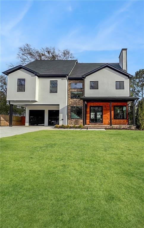 view of front of home featuring a garage, concrete driveway, fence, a front yard, and stucco siding