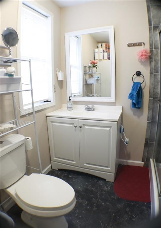 bathroom with a shower with door, vanity, and toilet