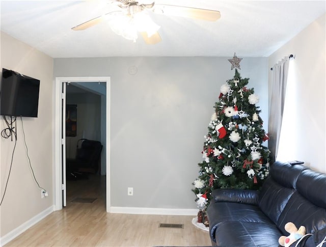 living room featuring light hardwood / wood-style floors and ceiling fan