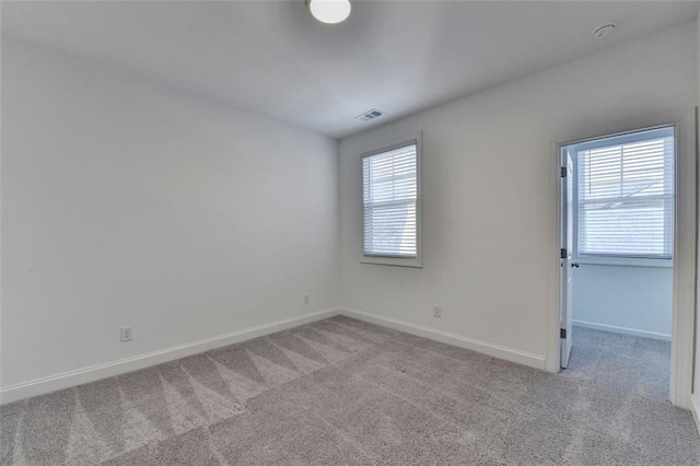 spare room with light colored carpet and a healthy amount of sunlight