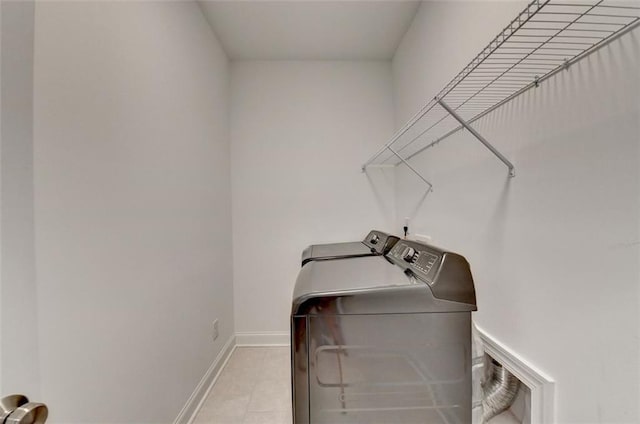 laundry room with independent washer and dryer and light tile patterned floors