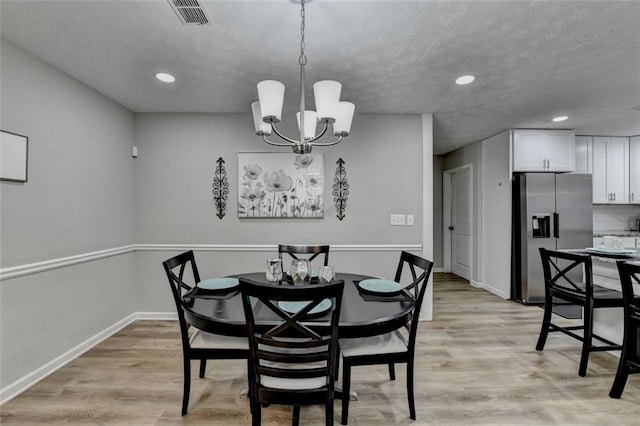 dining space featuring a chandelier and light wood-type flooring