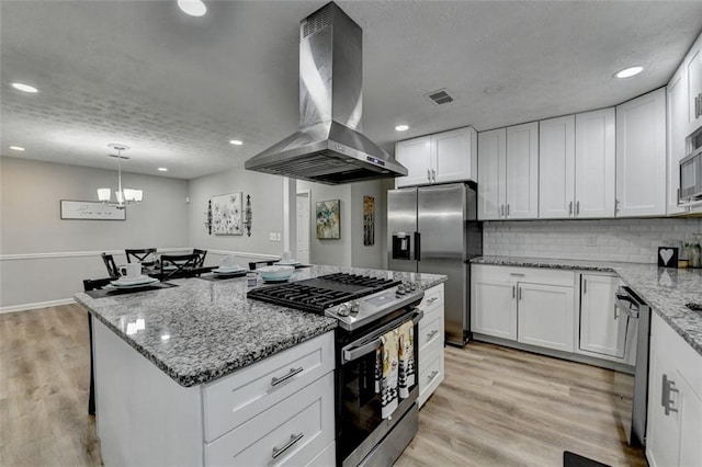 kitchen featuring white cabinetry, island range hood, stainless steel appliances, and light hardwood / wood-style flooring