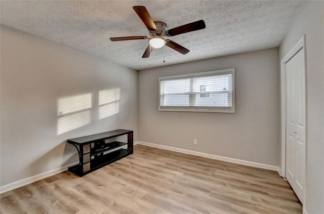 unfurnished bedroom with ceiling fan, light hardwood / wood-style flooring, a closet, and a textured ceiling