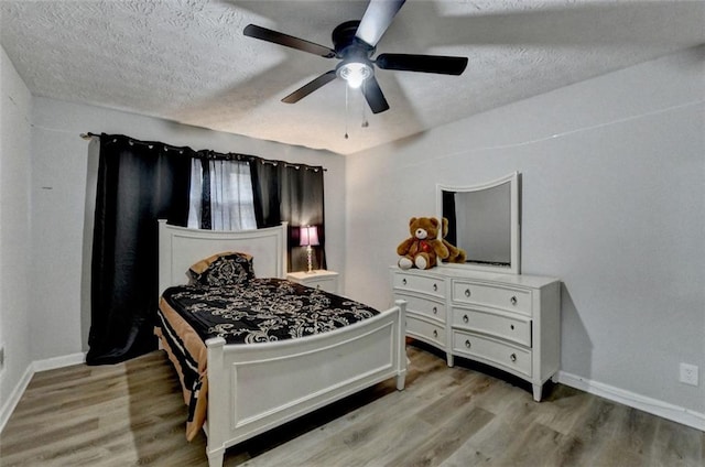 bedroom with ceiling fan, a textured ceiling, and light hardwood / wood-style flooring