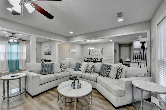 living room with a chandelier and light wood-type flooring