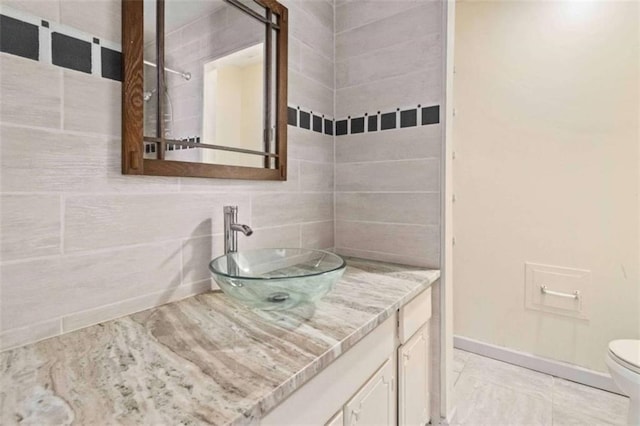 bathroom featuring decorative backsplash, vanity, tile walls, and toilet