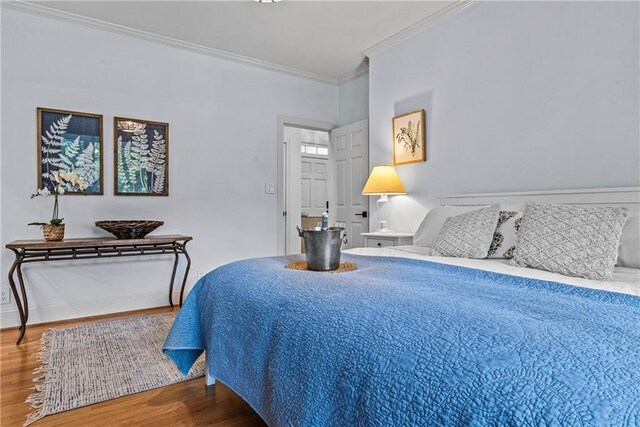 bedroom featuring wood-type flooring and ornamental molding