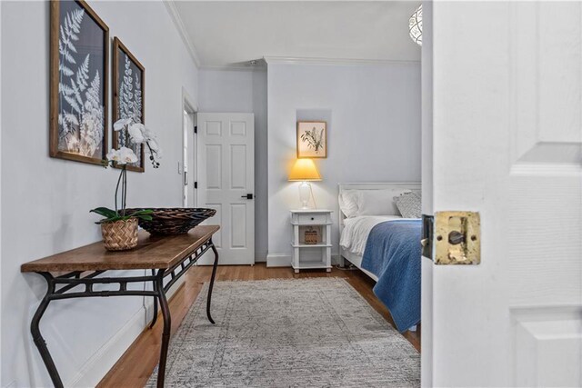 bedroom featuring ornamental molding and light hardwood / wood-style flooring