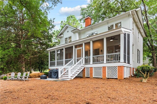 rear view of property featuring a sunroom and ceiling fan