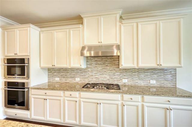4895 Sterling Close, Buford, GA 30518 - kitchen with under cabinet range hood, stainless steel appliances, light stone countertops, backsplash, and white cabinets