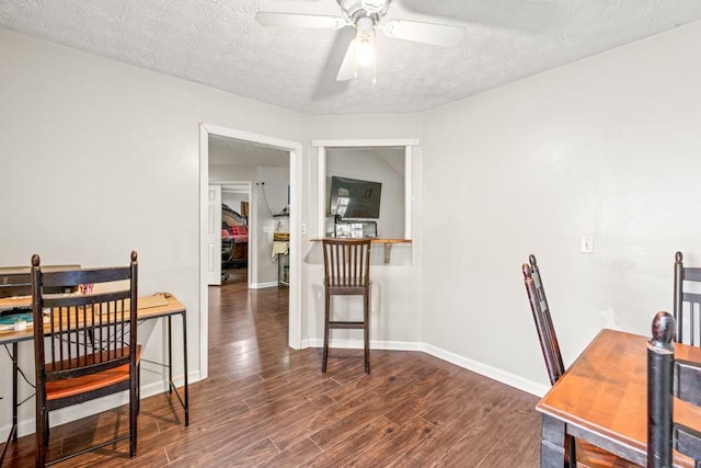 home office featuring a textured ceiling, ceiling fan, wood finished floors, and baseboards