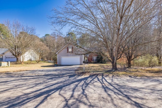 view of front of house with a garage, driveway, and an outdoor structure