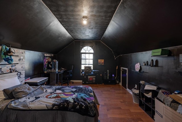 bedroom with vaulted ceiling and wood finished floors